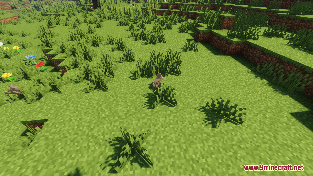 Small custom brown rabbit sitting among tall grass and green bushes