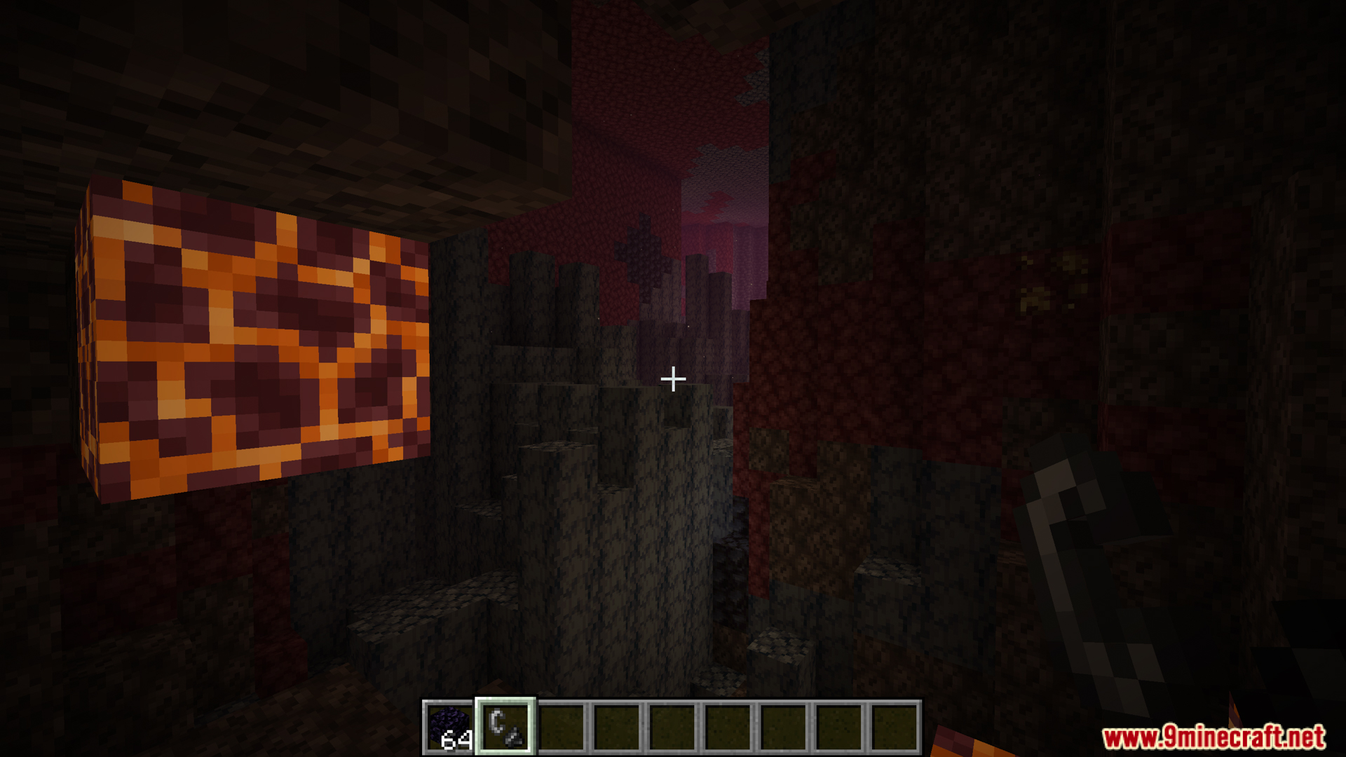 A glowing magma block inside a dark Nether cave