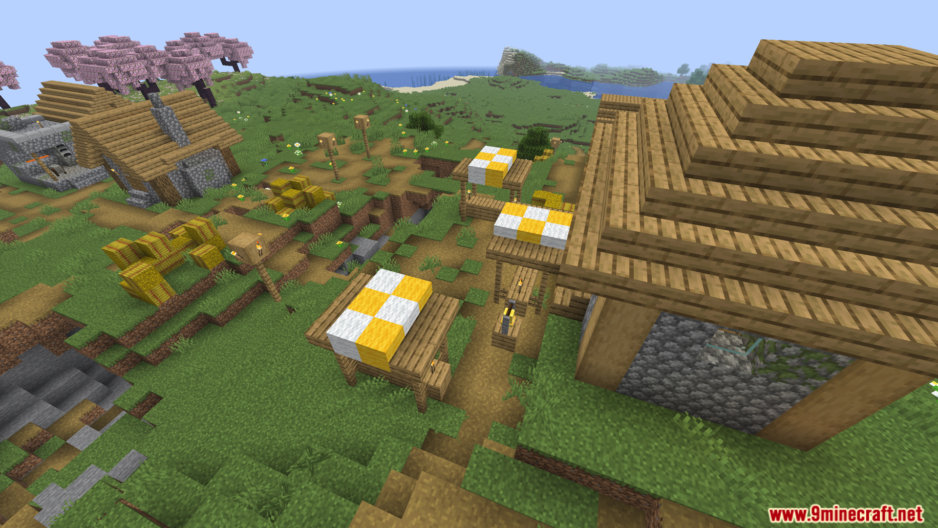 Village with market stalls and cherry blossom trees nearby