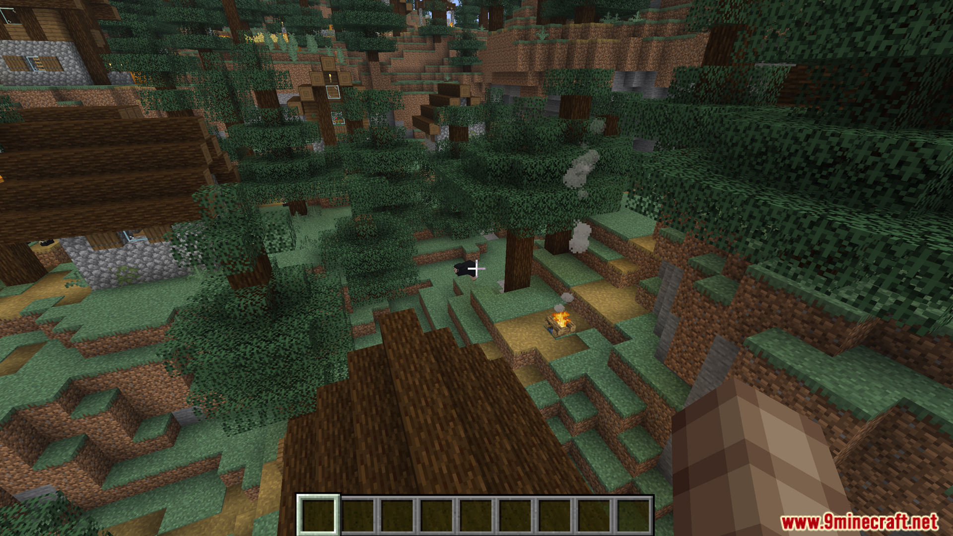 Player looking down at a small campfire in a dense spruce forest