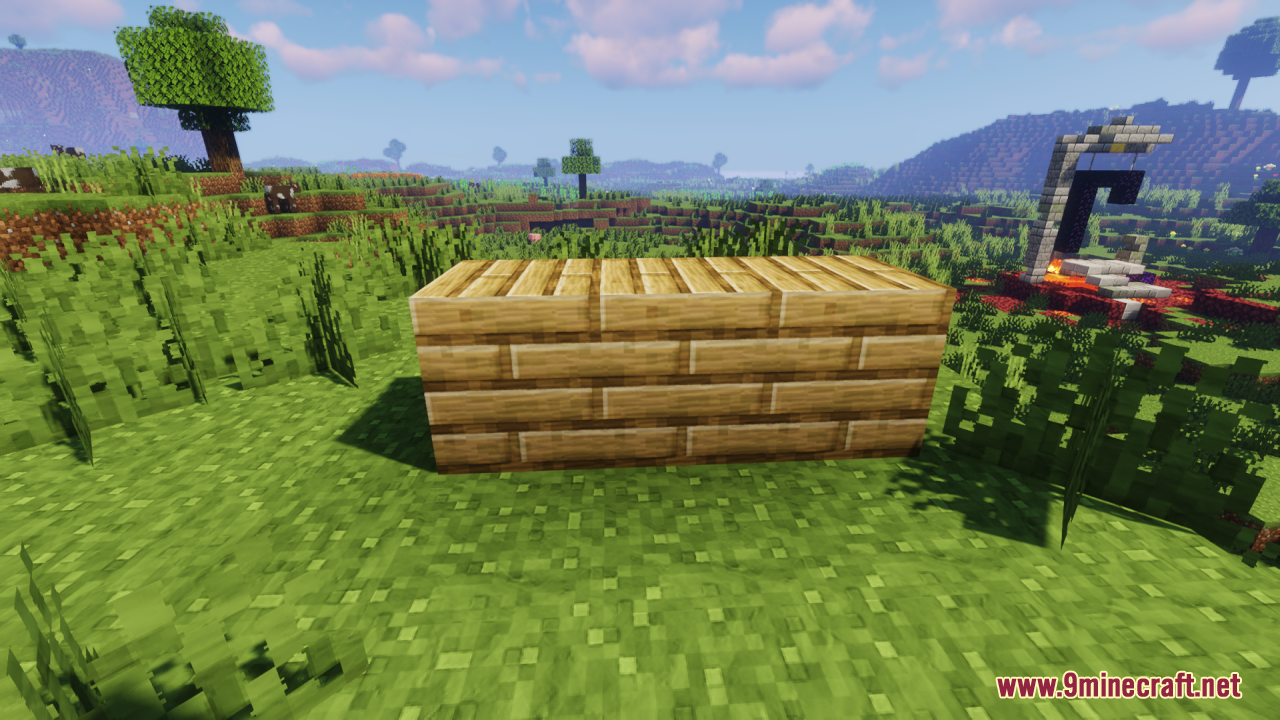 Wooden plank blocks arranged on grass near a ruined portal