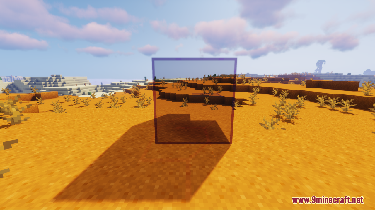 A tinted glass cube casting a shadow on sand