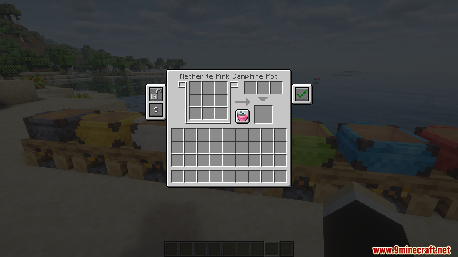 Various colored campfire pots placed on wooden blocks near water