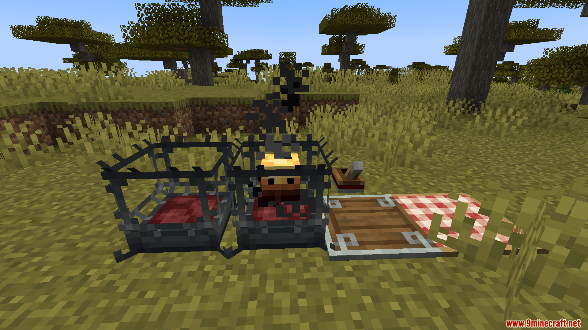 Burning metal cage next to an empty cage and blanket