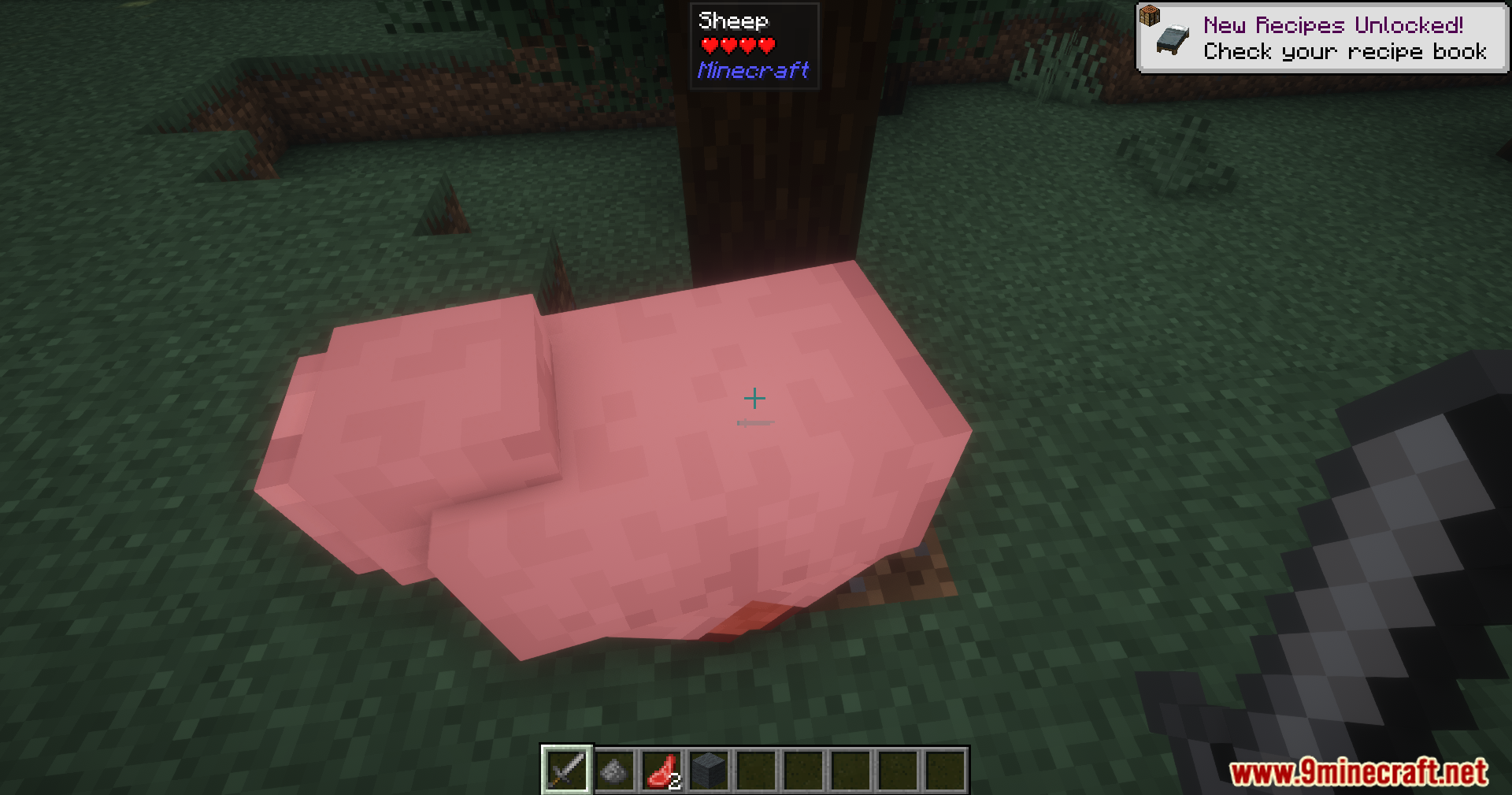 A strange pink fleshy creature lying on the grass