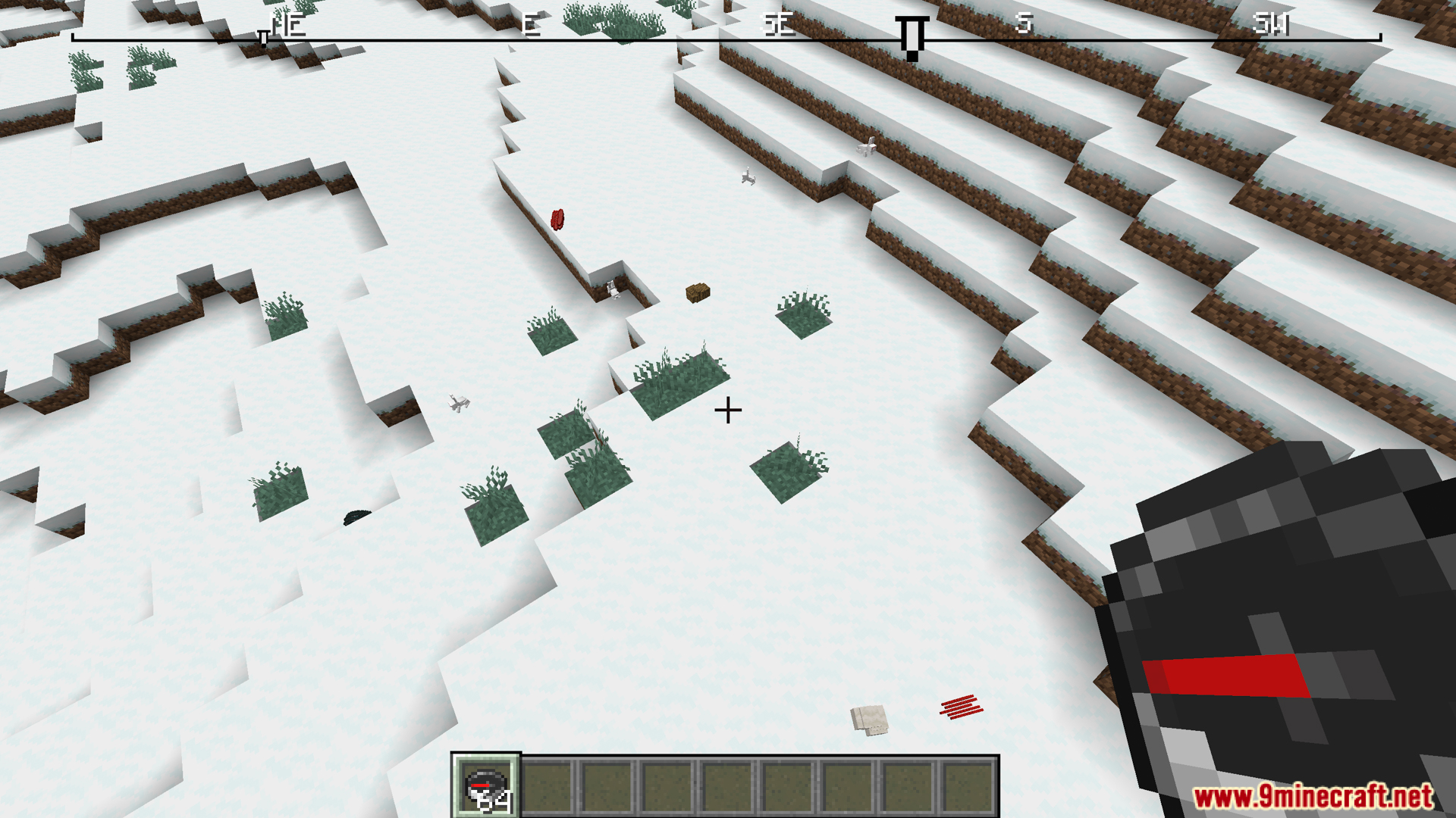Looking down at snowy terrain with compass and top ribbon