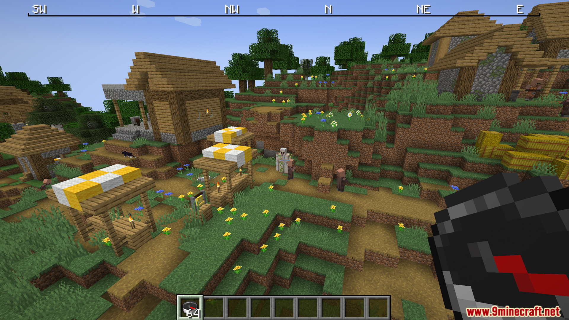 Minecraft village view with compass held and top compass ribbon