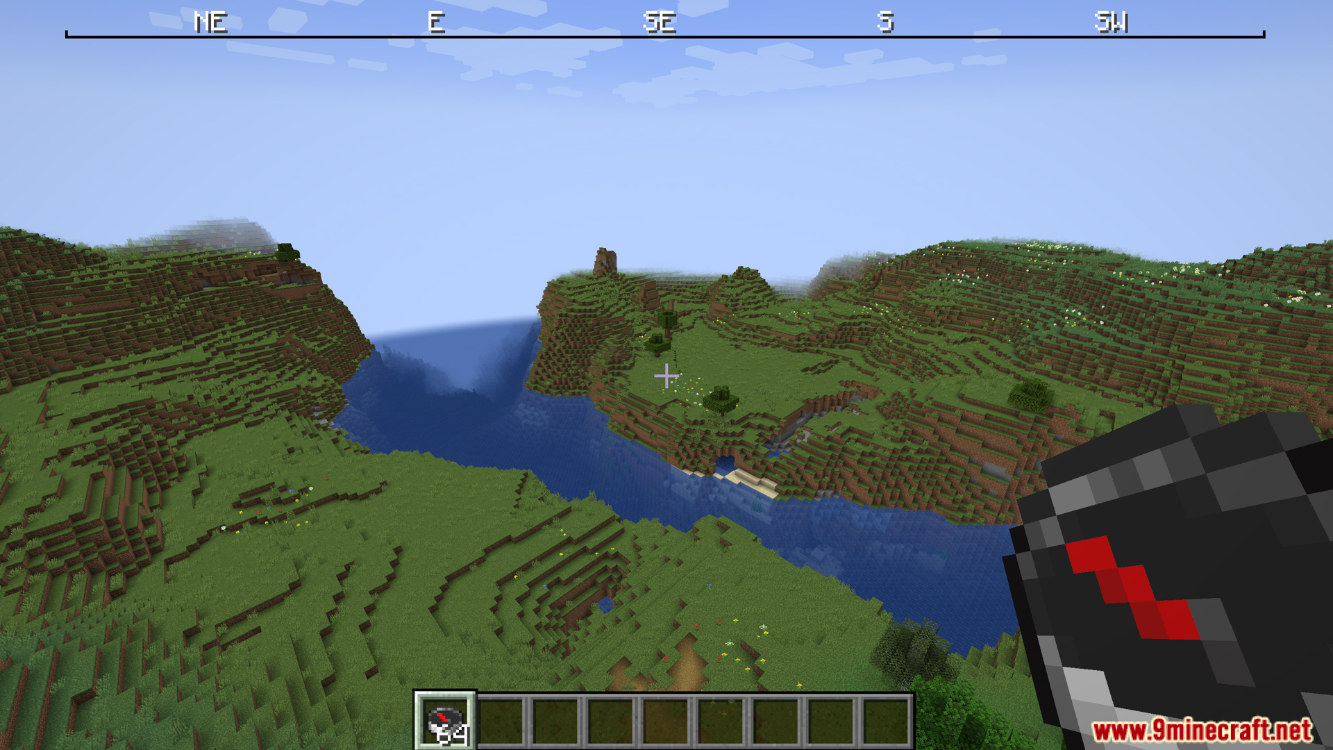 Grassy landscape with river compass held and top compass ribbon