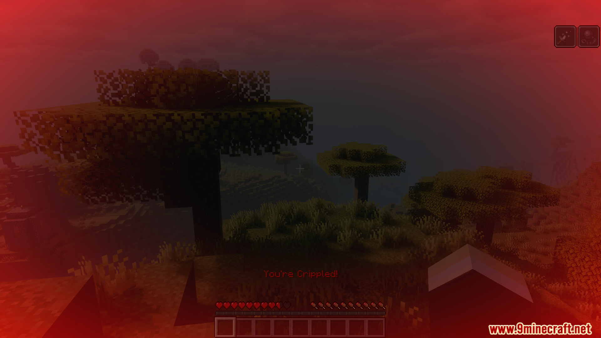 Crippled status effect with red overlay in a savanna biome