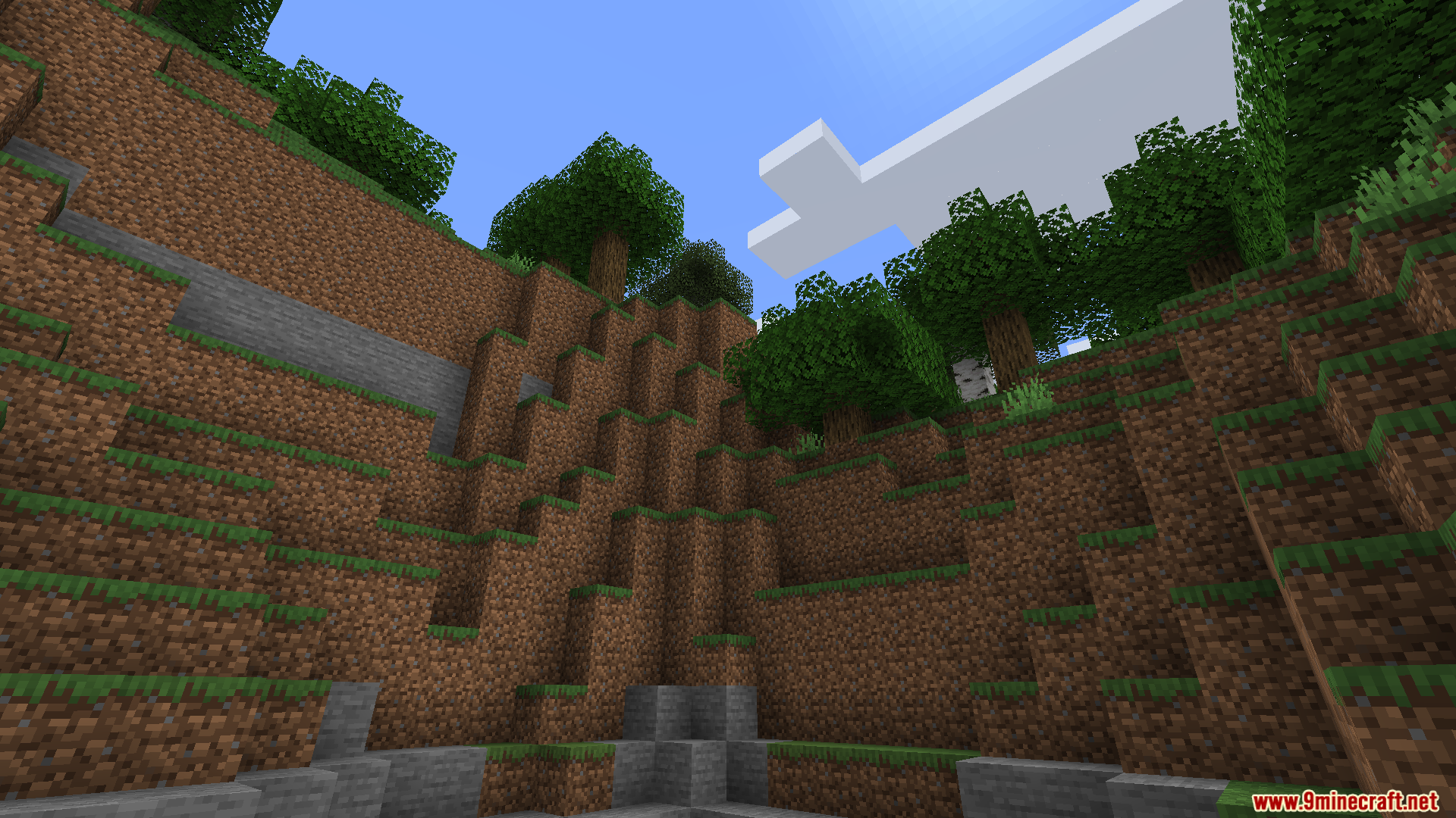 A large, terraced quarry dug into a grassy hill