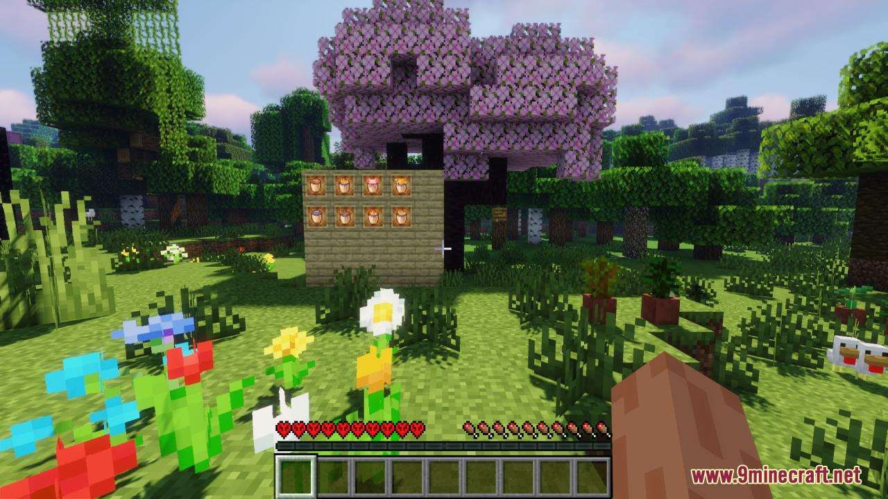 Wooden wall displaying various buckets next to a pink cherry tree