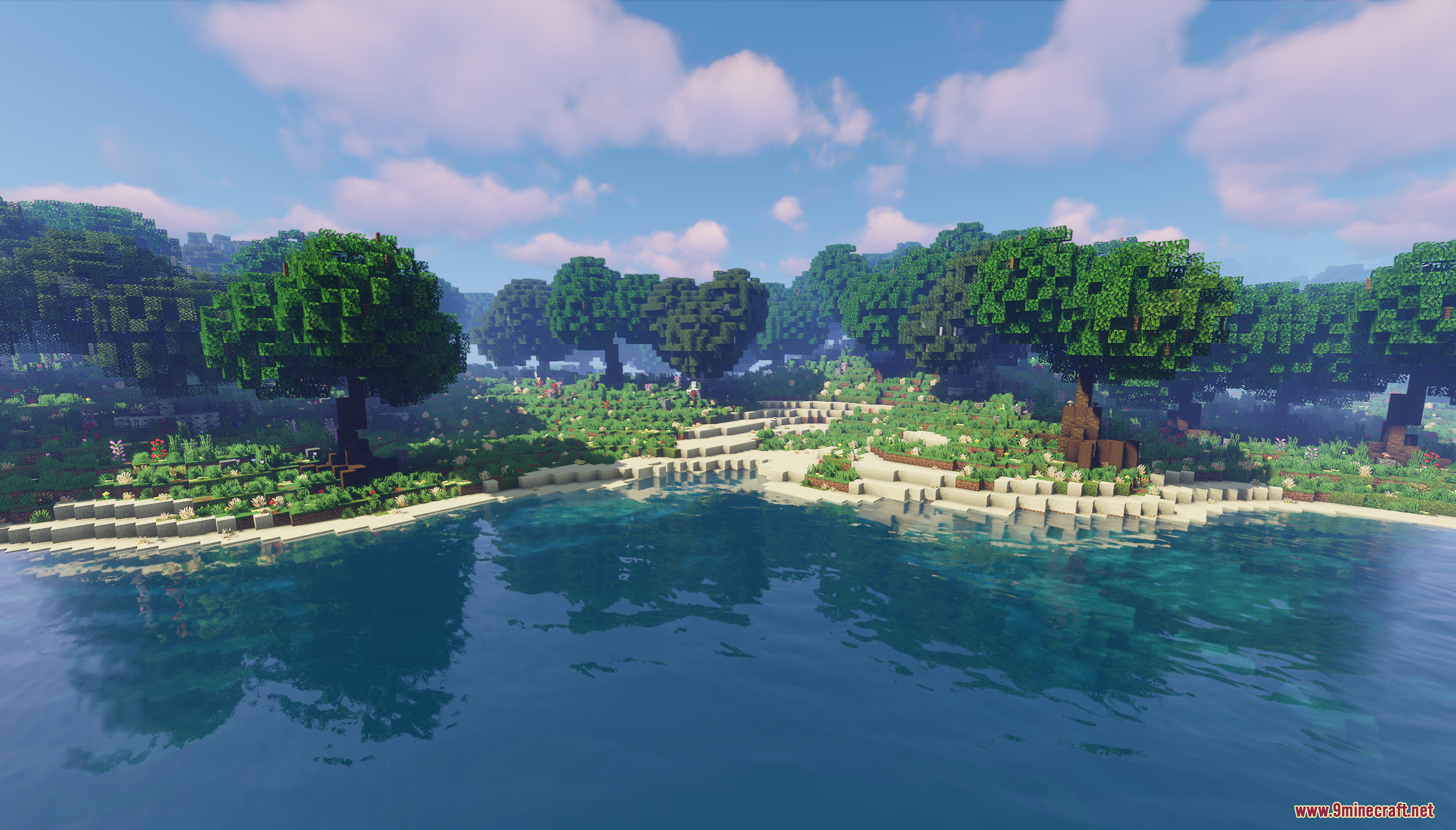 Custom trees lining the sandy beach of a calm blue lake
