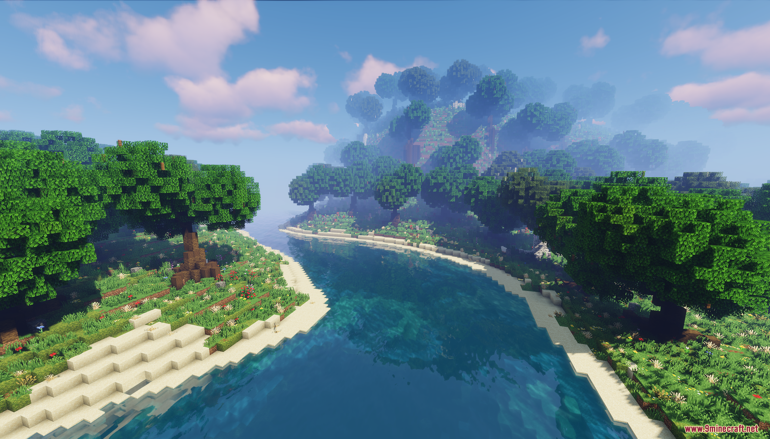 Winding river leading towards a foggy forested hill in the distance