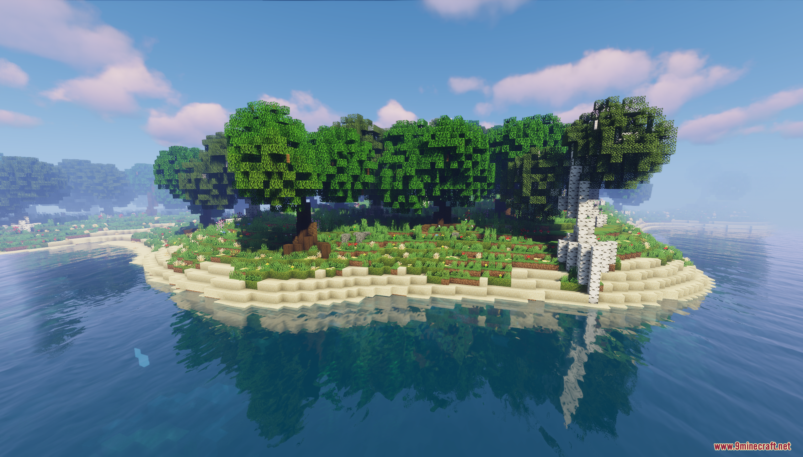 Small forested island with sandy shores surrounded by calm blue water