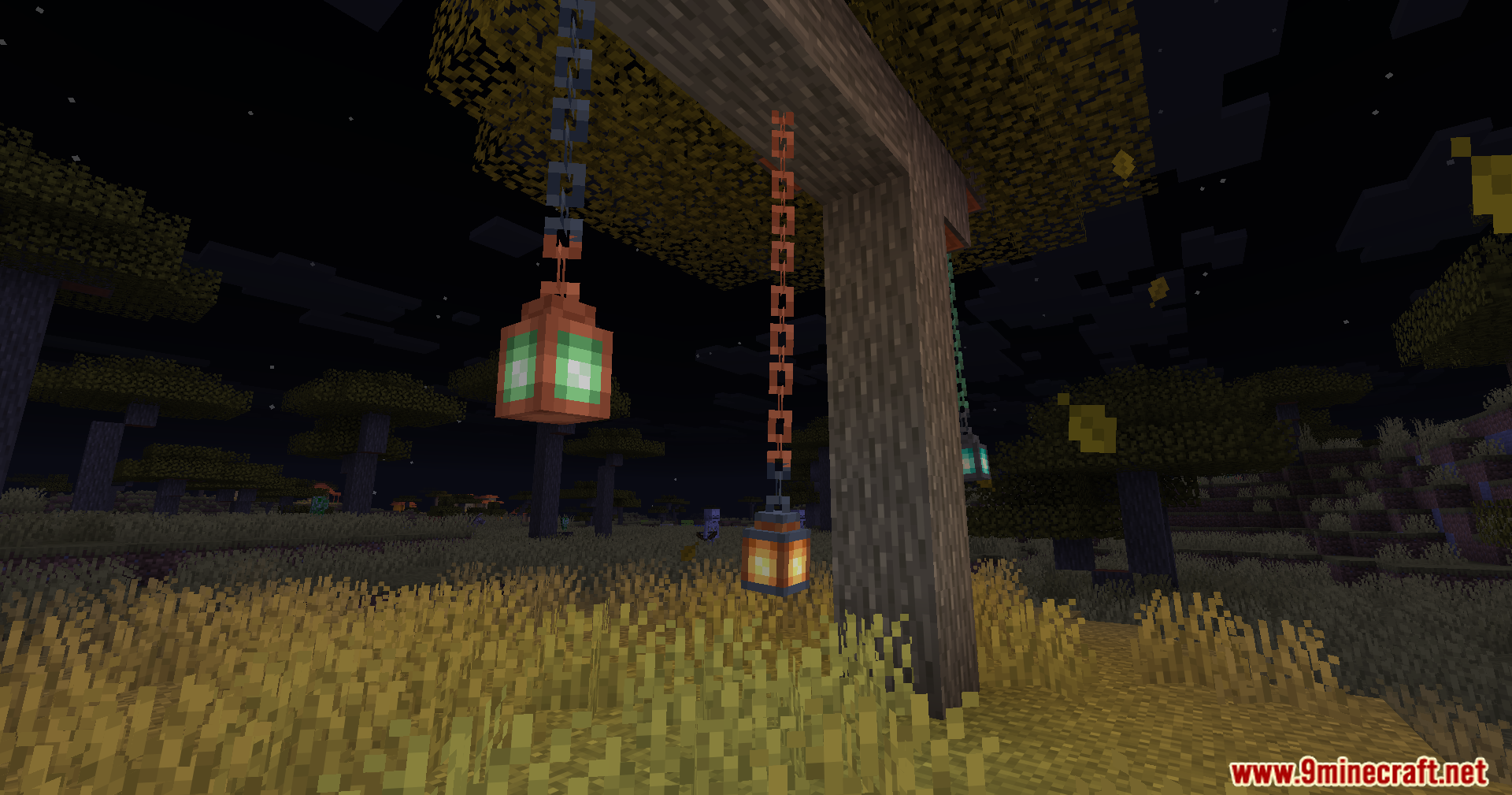 Three lanterns hanging straight down from a wooden post structure