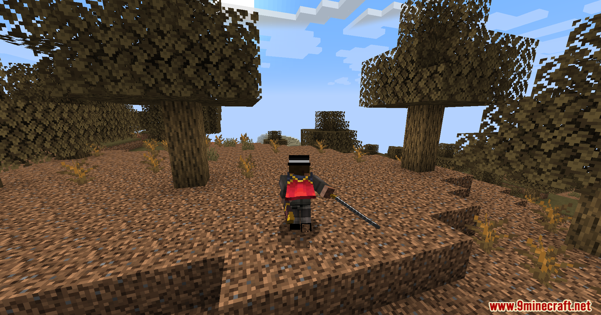 Player character with a red cape running through wooded badlands