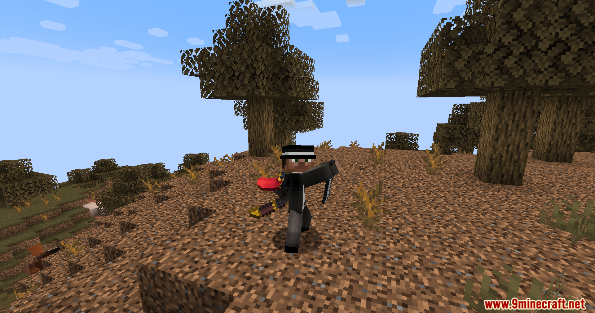 Player wearing top hat and cape holding sword in badlands biome