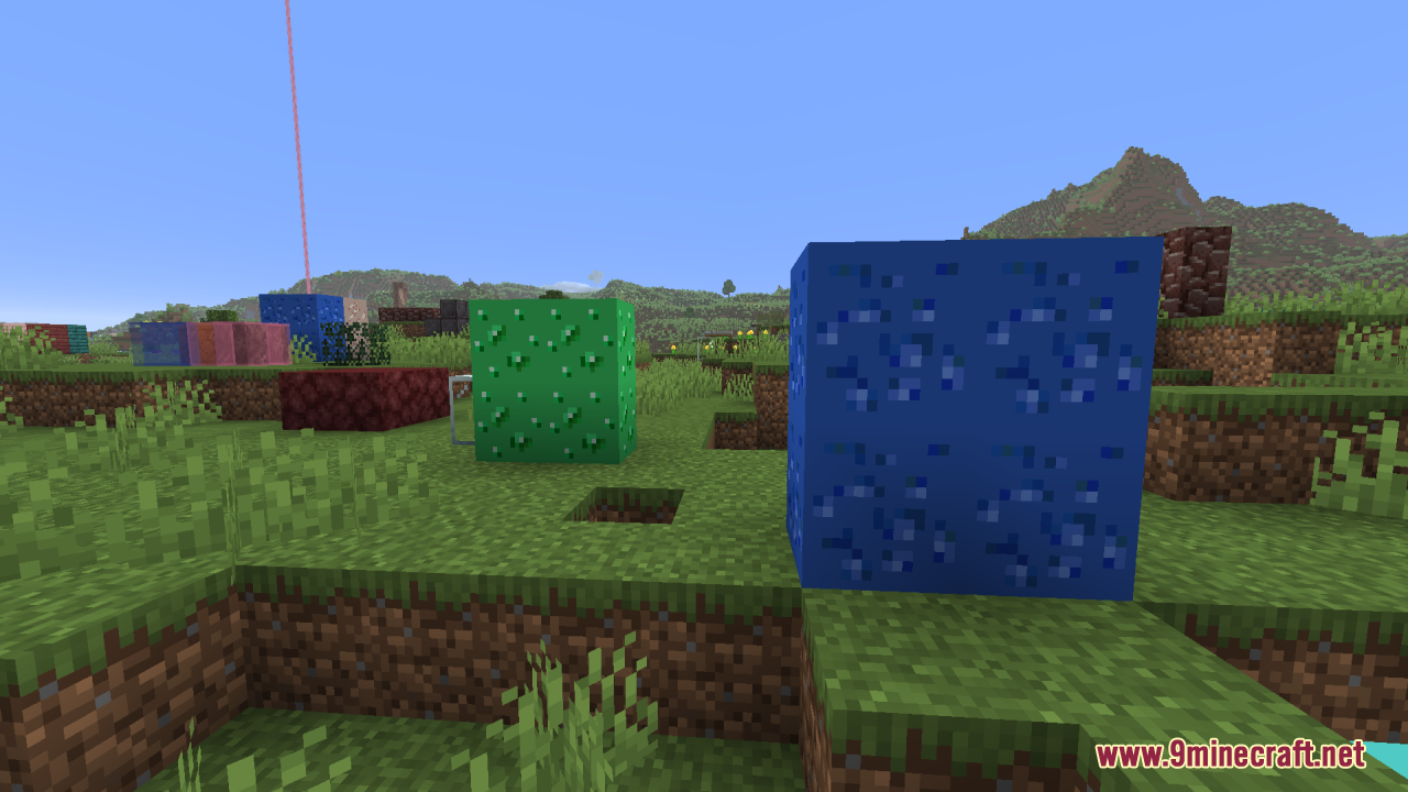 Giant glowing emerald and lapis ore blocks sitting on grass