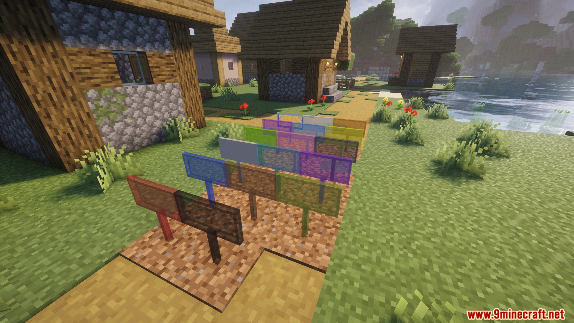 Several different colored stained glass signs placed outside in a village