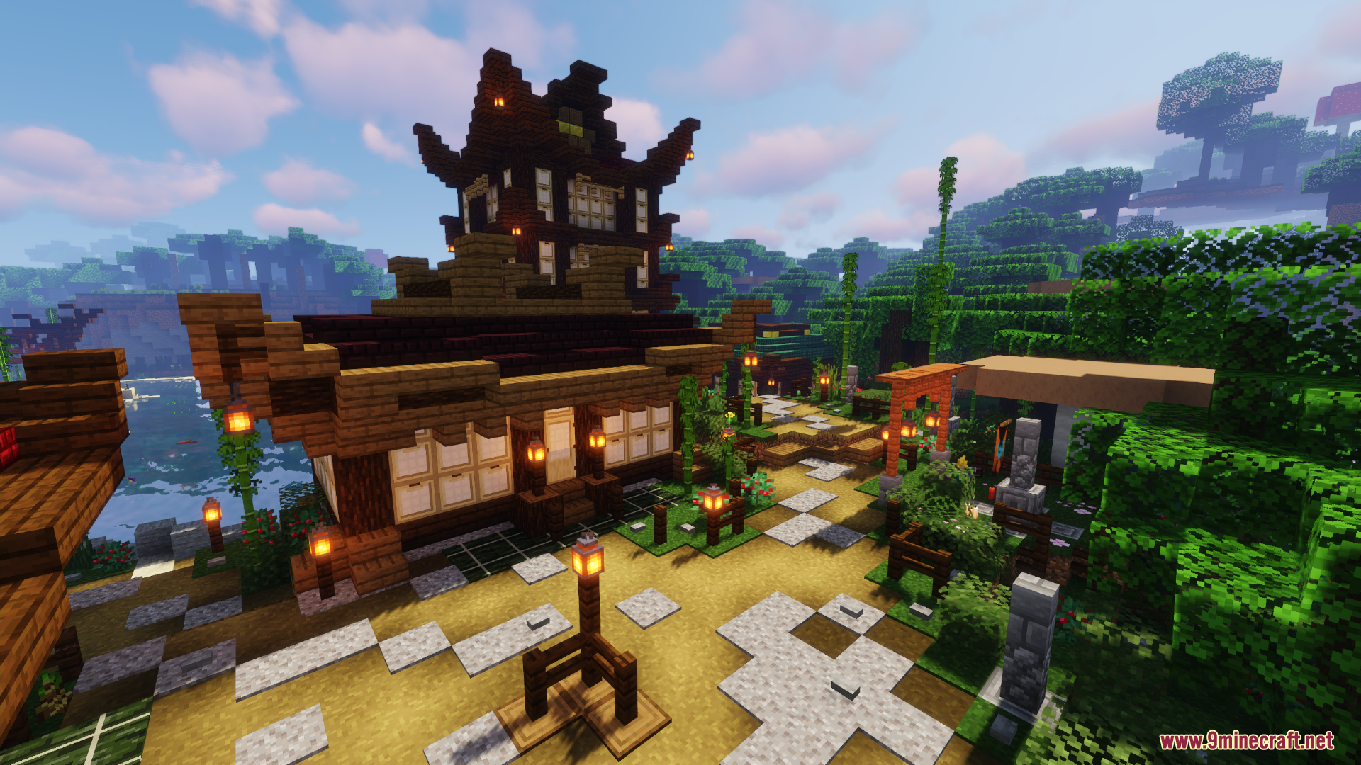 Tall wooden pagoda and traditional houses with lanterns along stone pathways