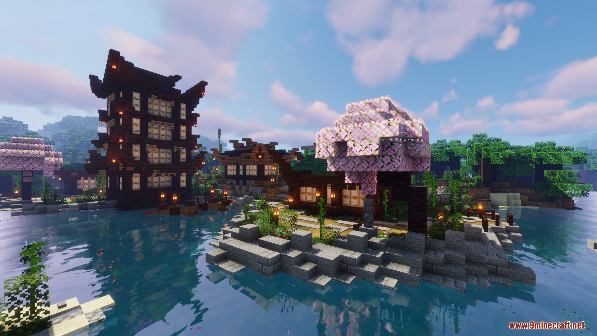 Pink cherry blossom tree on small island near traditional houses