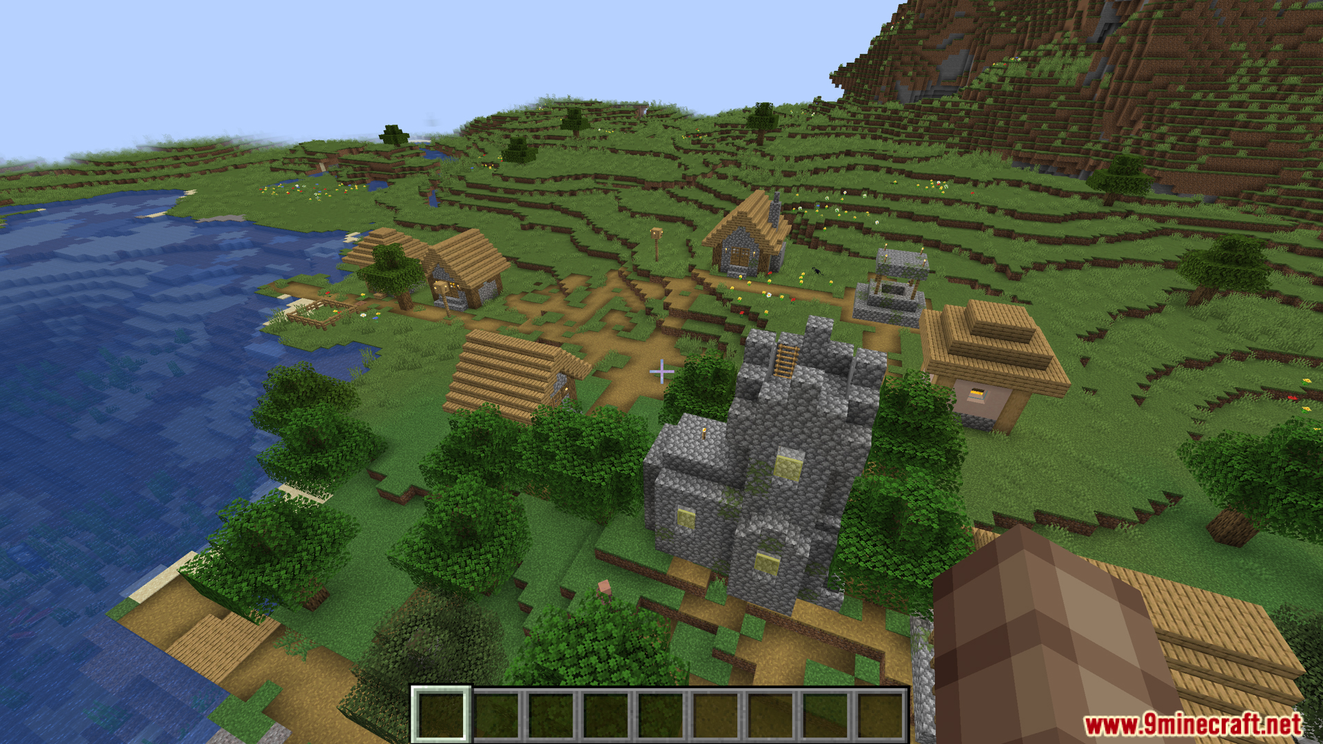 An aerial view of a Minecraft village by the water