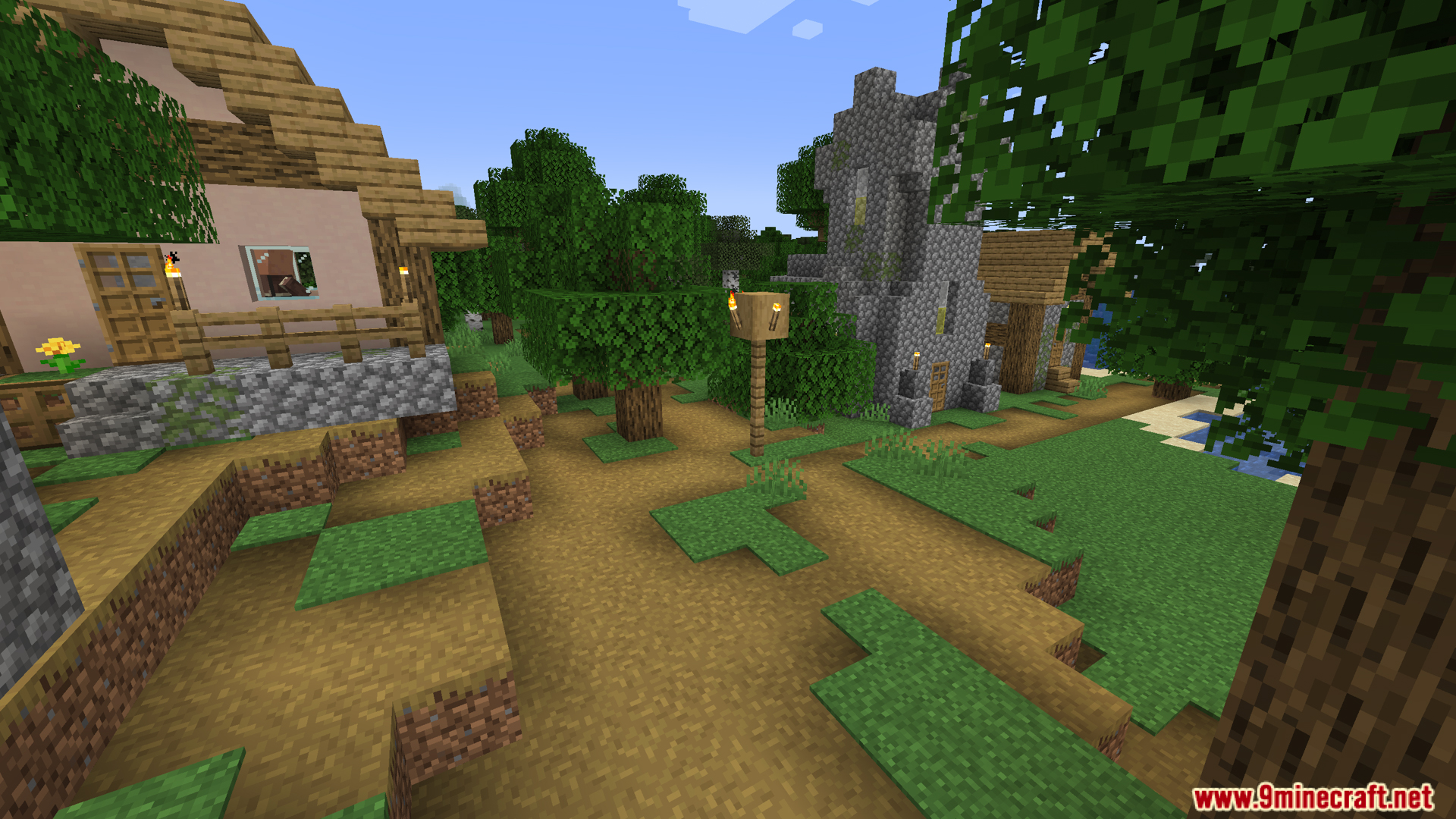 View of a dirt path winding through a grassy village