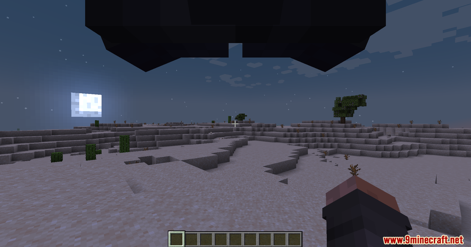 Nighttime desert landscape with a large object overhead