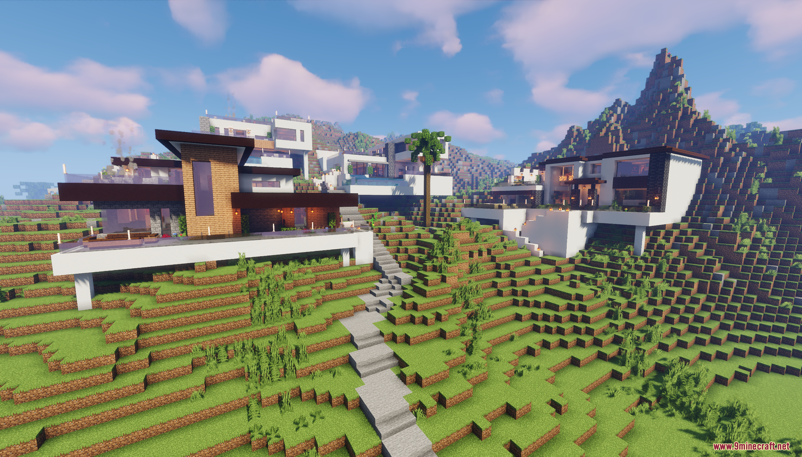 Modern houses built on a grassy hillside with stone stairs leading up