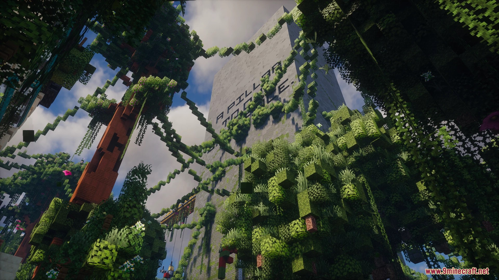 Looking up at a massive overgrown pillar structure with hanging vines