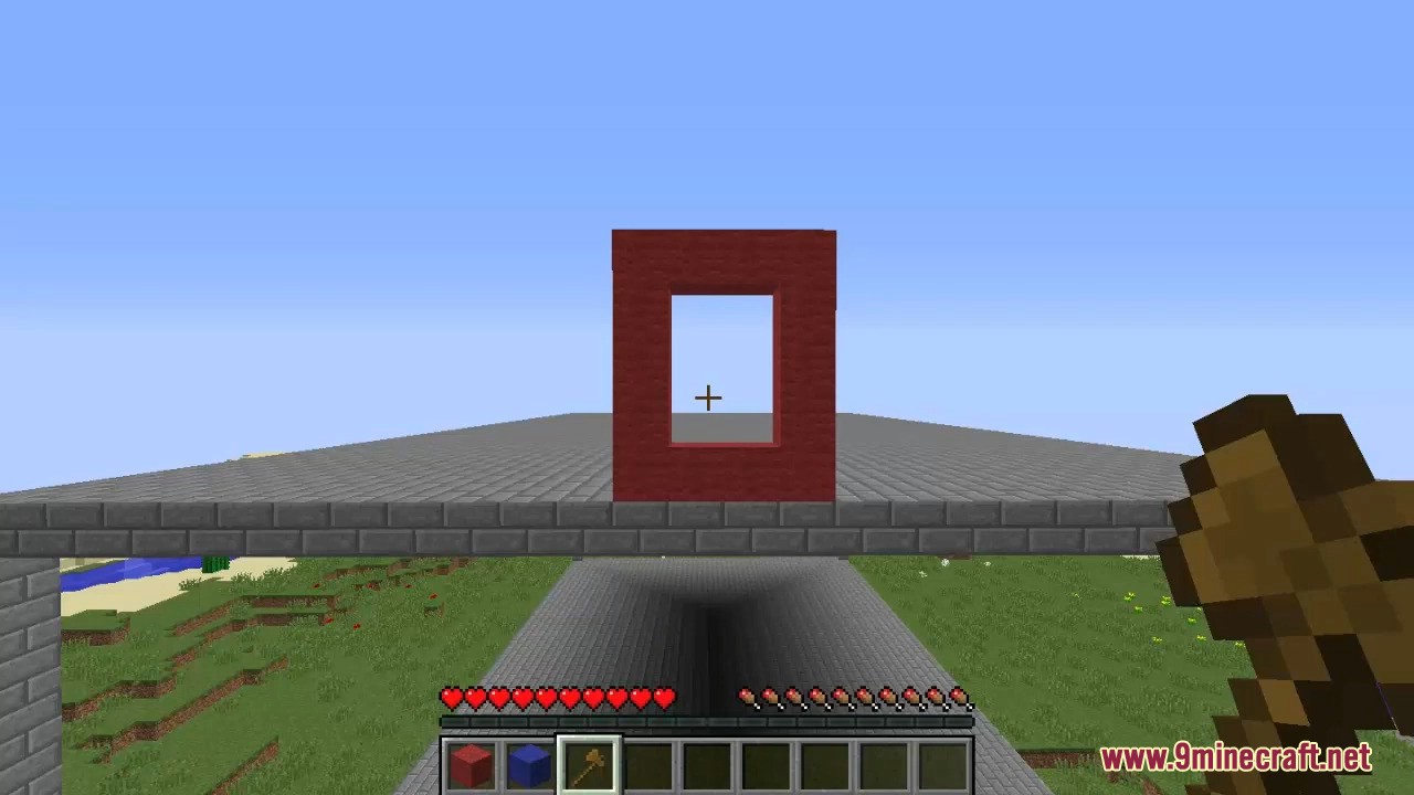 Player holding wooden axe looking at red portal frame structure