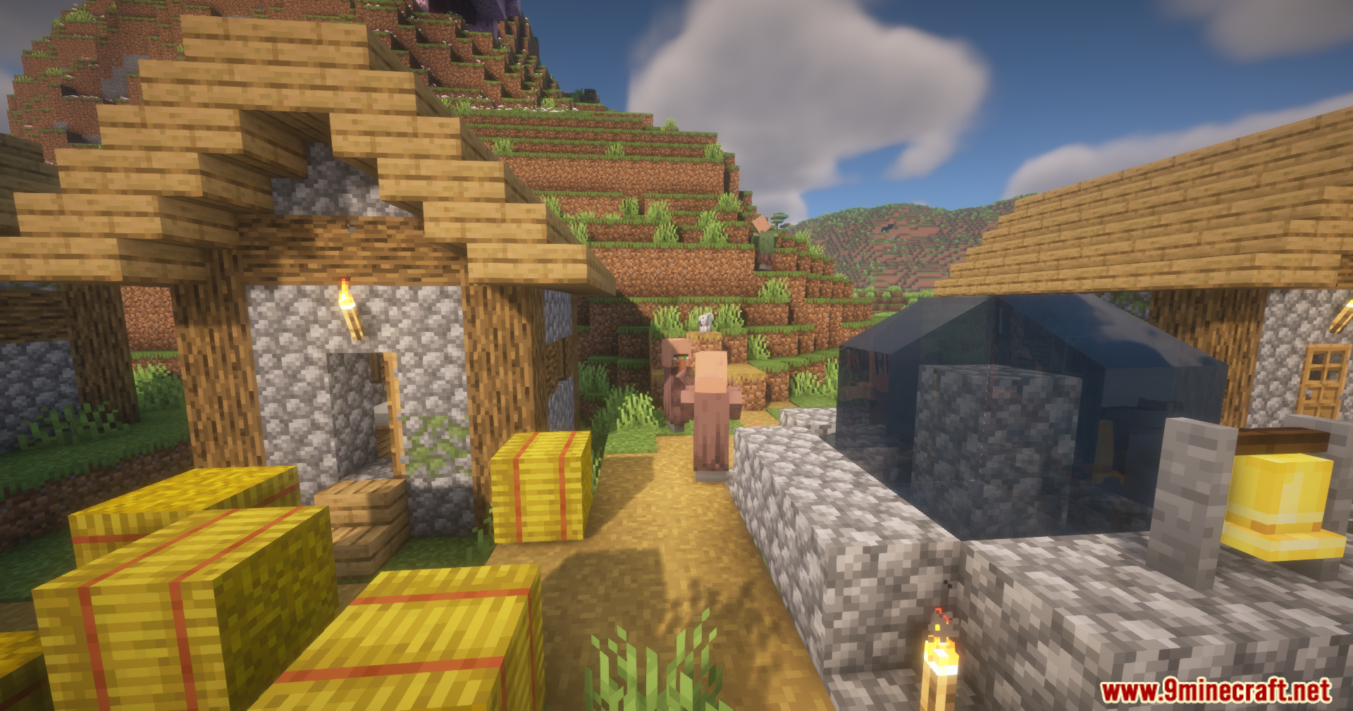 Close view of village houses with hay bales and a villager