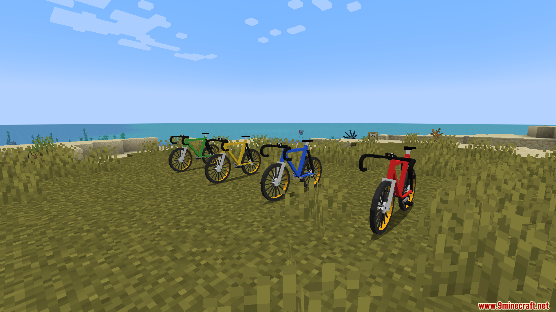 Four different colored bicycles parked together on the grass