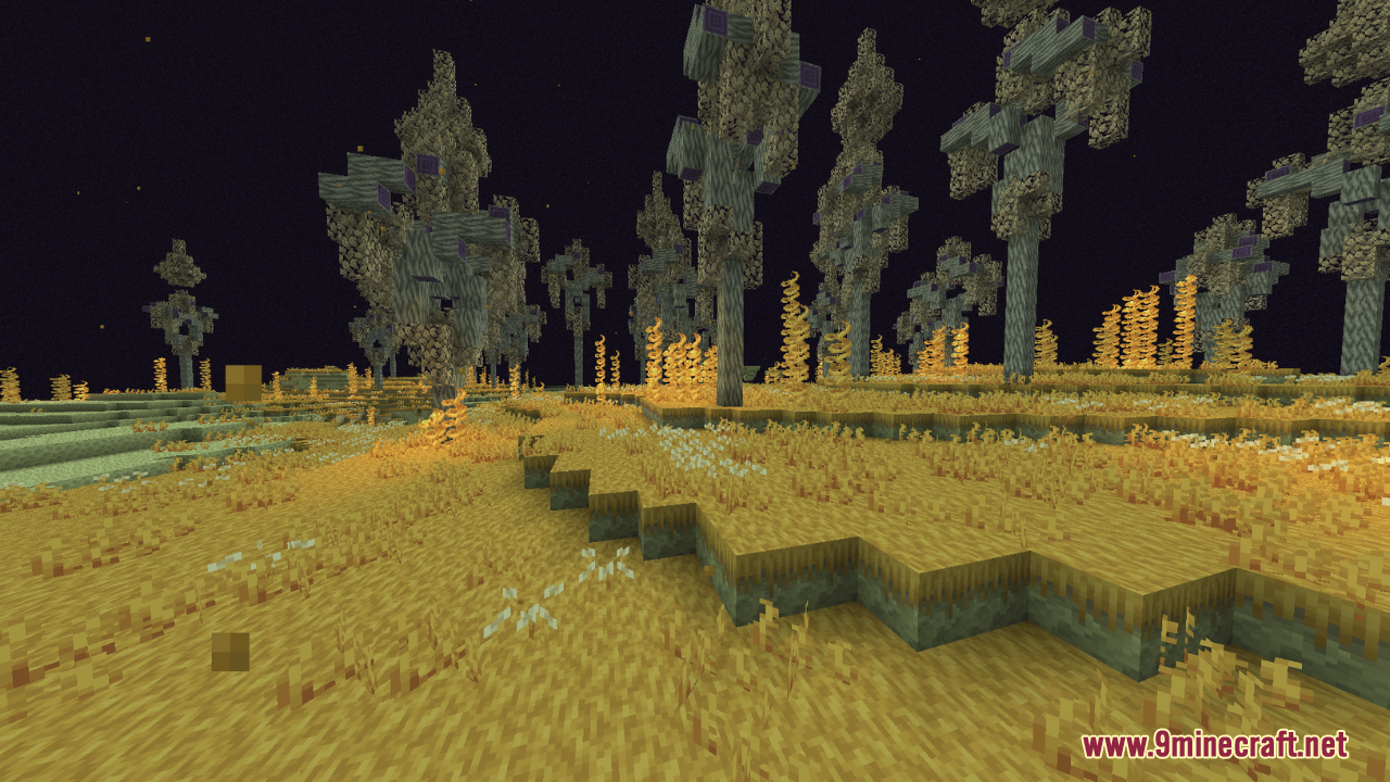 A barren landscape with strange trees and yellow grass under a dark sky