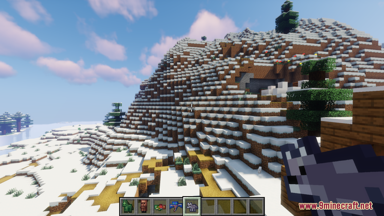 Player holding a tiny wolf spawn egg in a snowy mountain biome