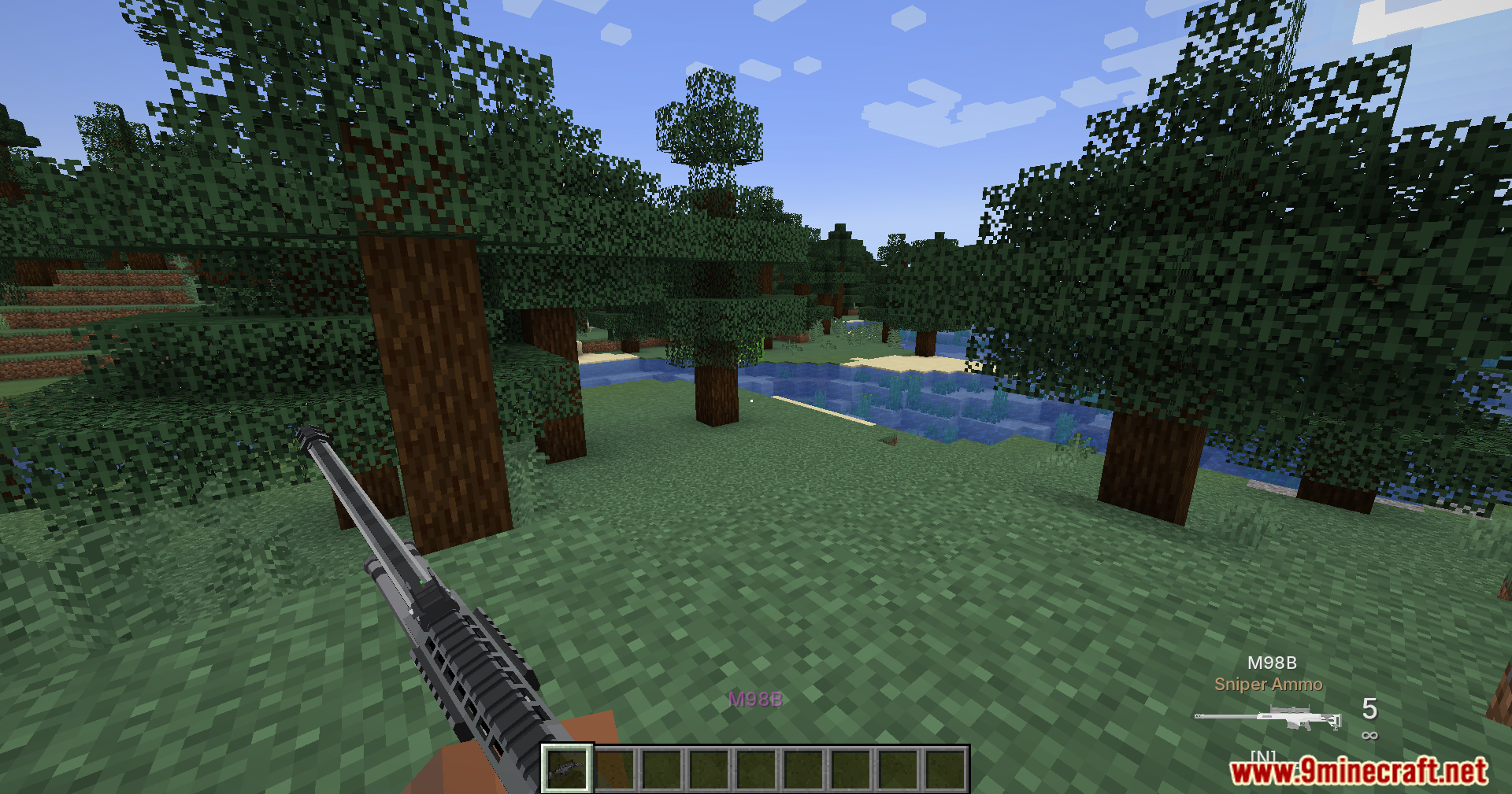 Player holding an M98B sniper rifle in a forest environment