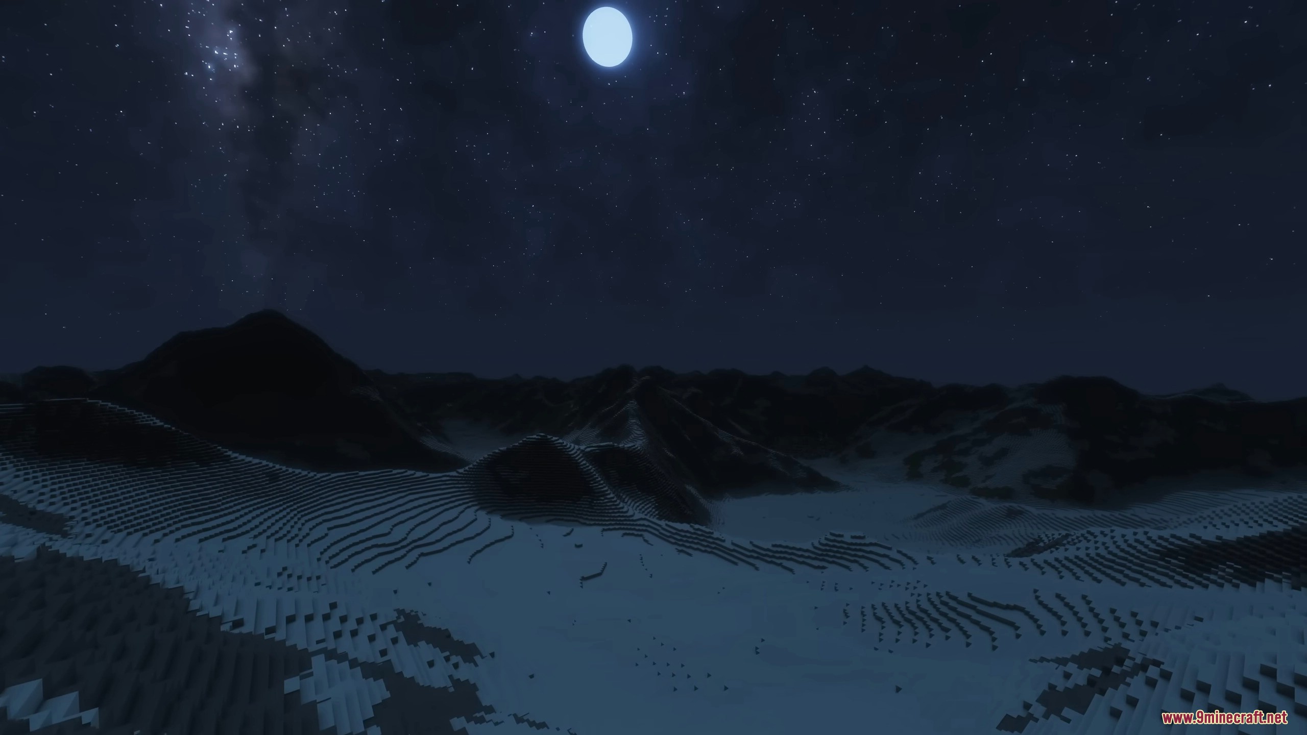 Night view of snowy terrain under a bright moon