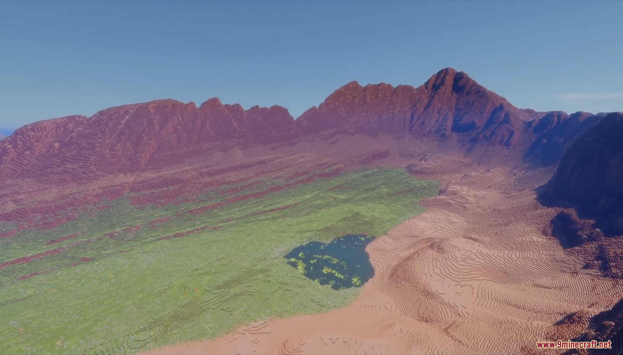 Wide valley with a small lake surrounded by mountains