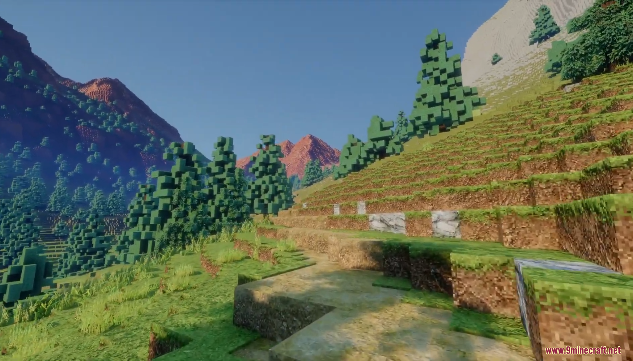 Aerial view of a deep valley between red and grey mountains