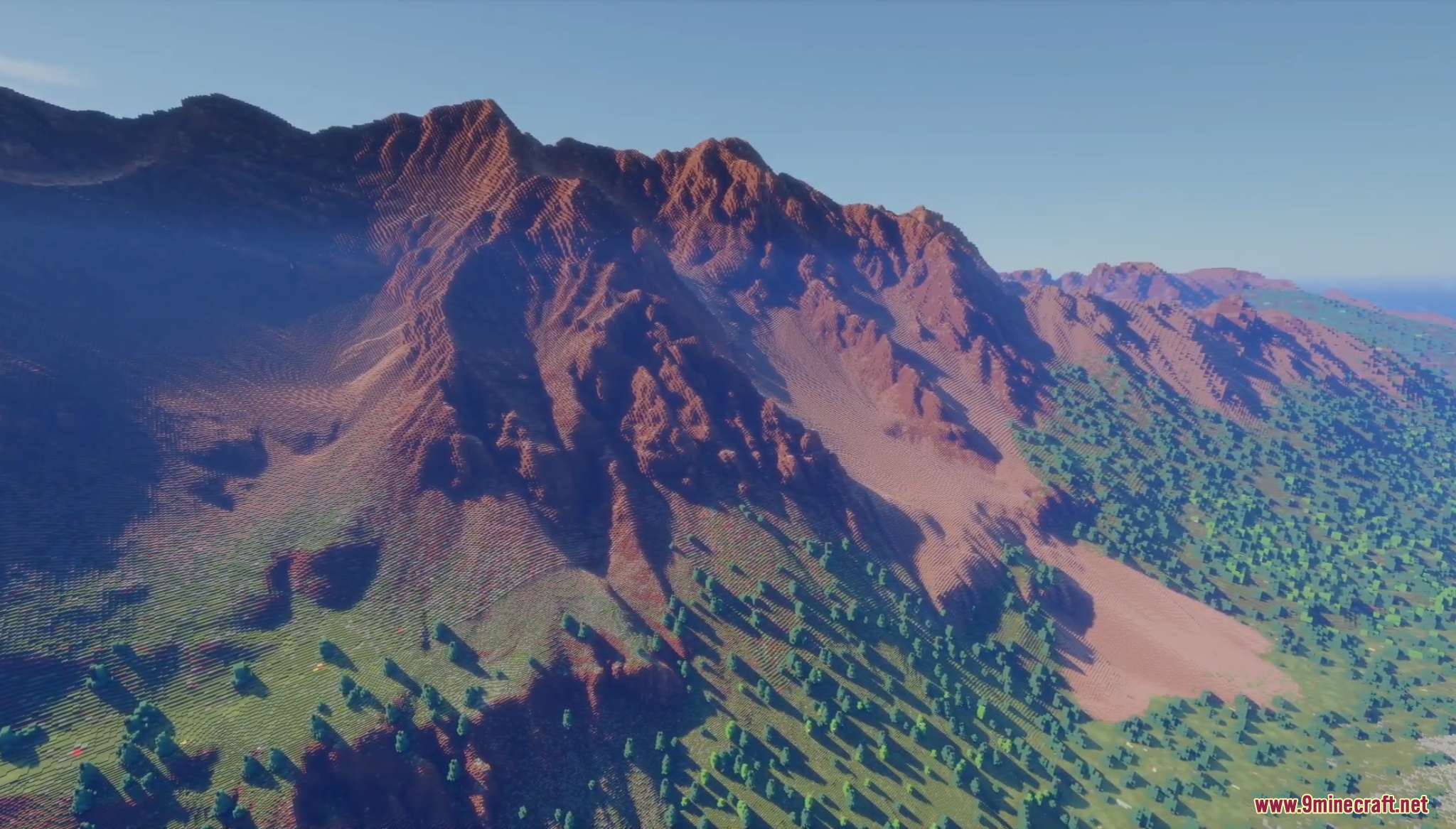 Large mountain range with red rock and green valleys