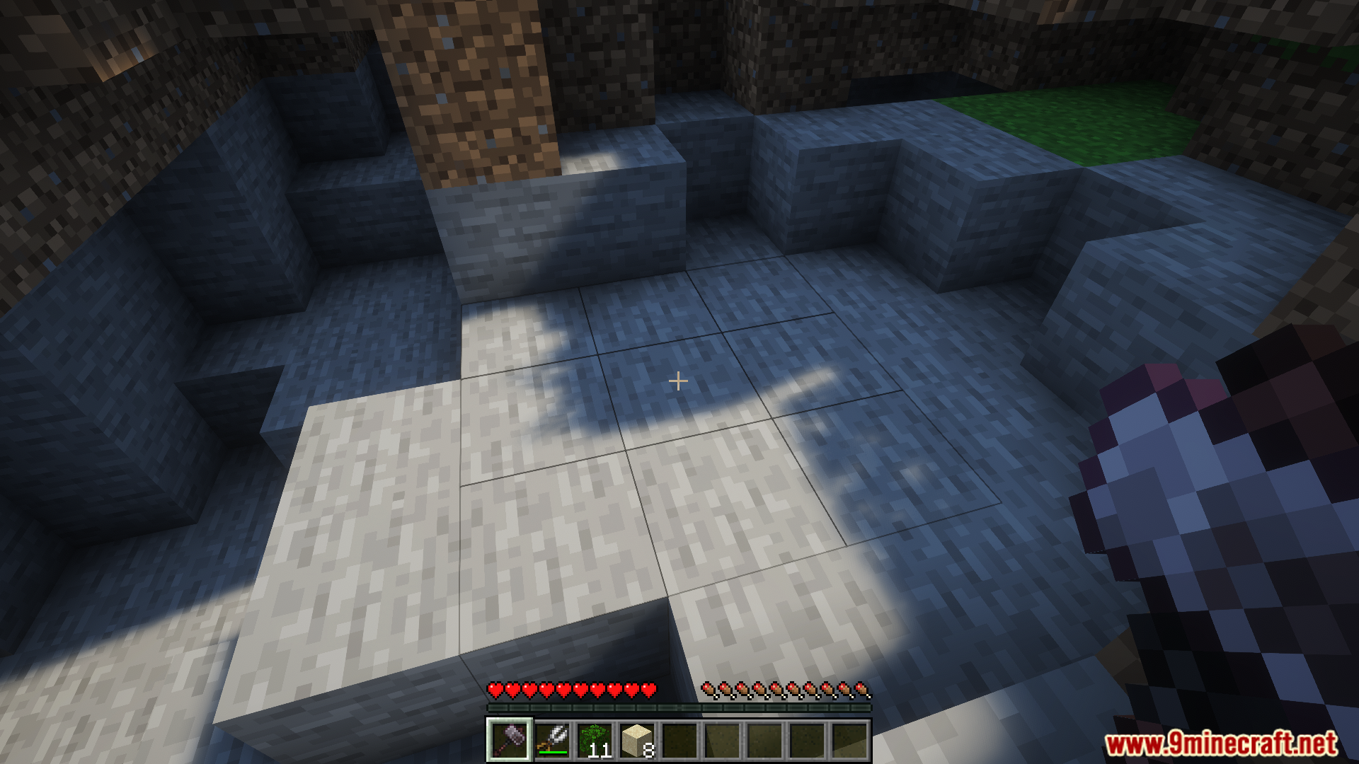 Player aiming a hammer at a large grid on stone blocks