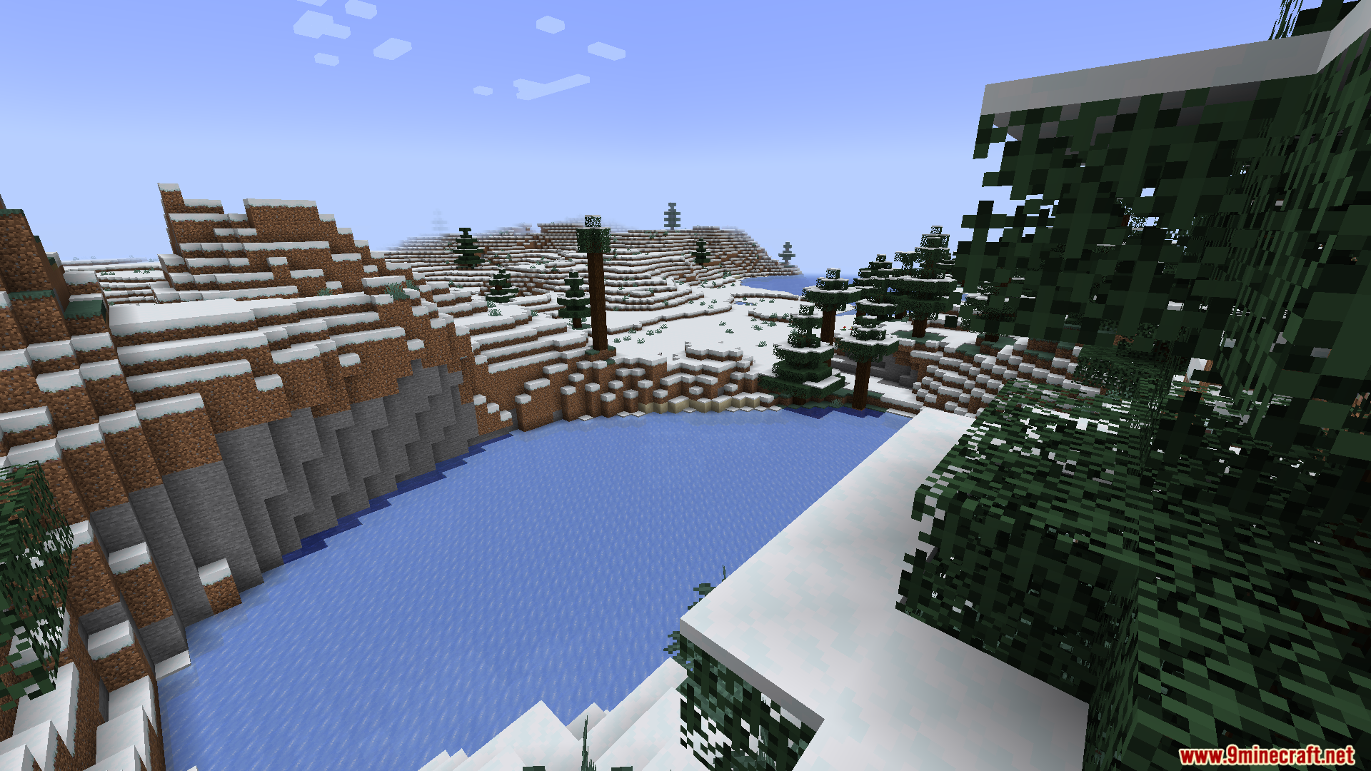 A large lake surrounded by a snowy, forested landscape