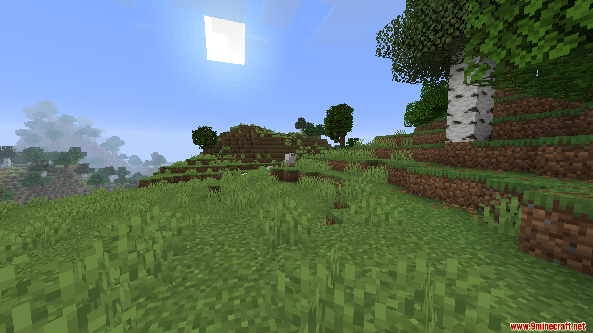 WorldWeaver Neoforge Mod Screenshot 6 Grassy hillside with sheep and trees under a bright sun