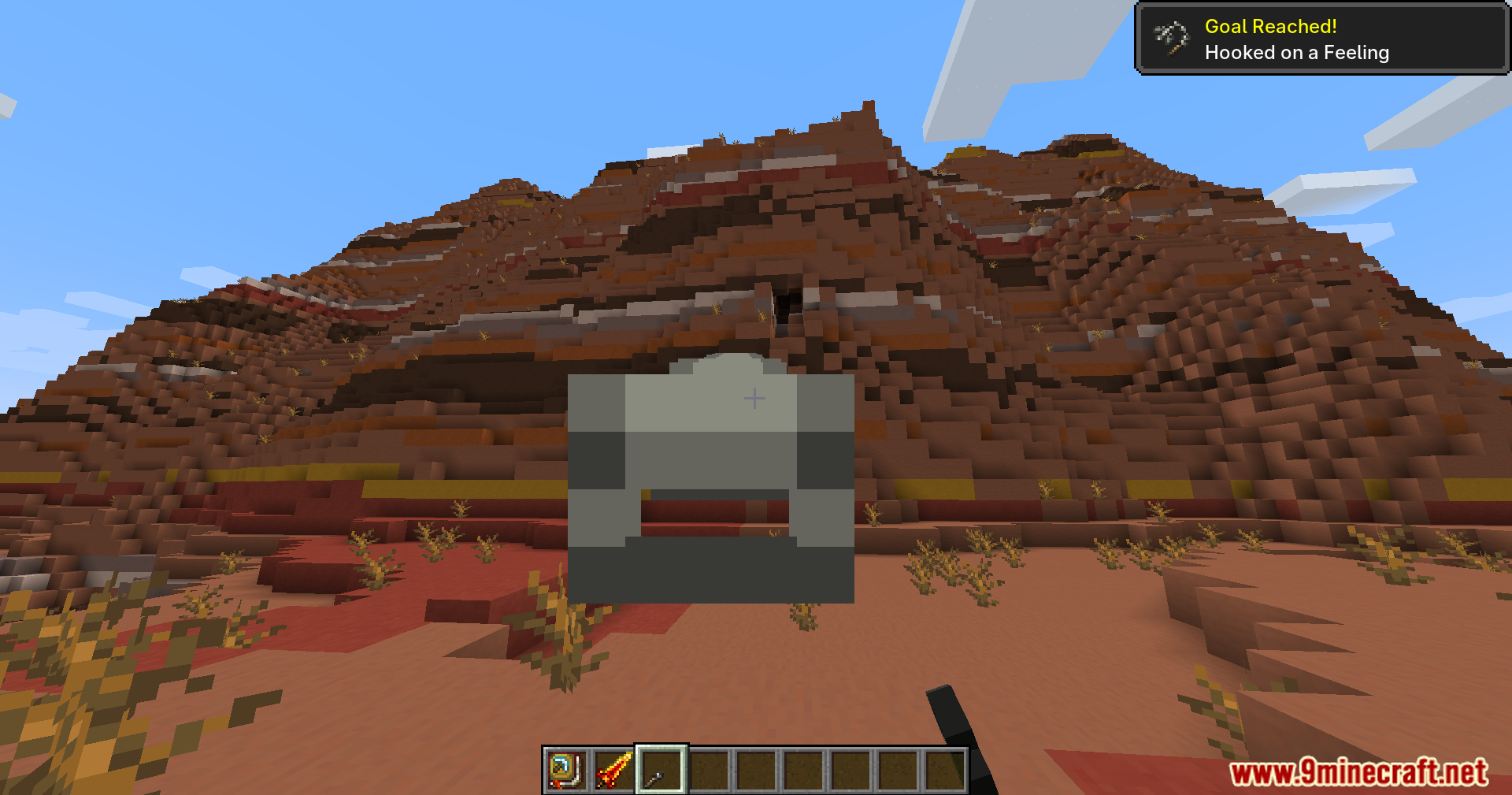 First person view of a mesa biome with a helmet icon