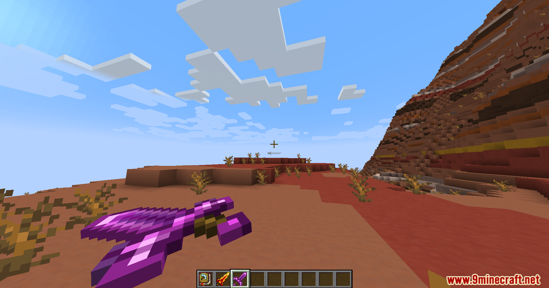 Player holding a purple magical sword in a desert