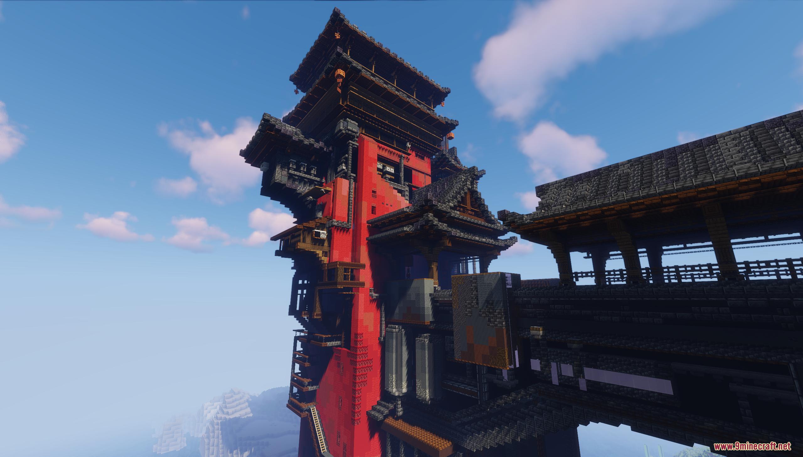 Close view of the tall red tower and wooden bridge