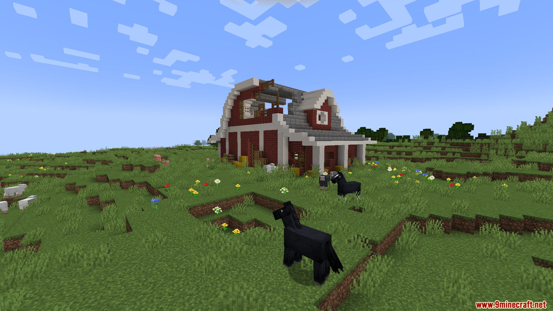A large, dilapidated red barn in a grassy field