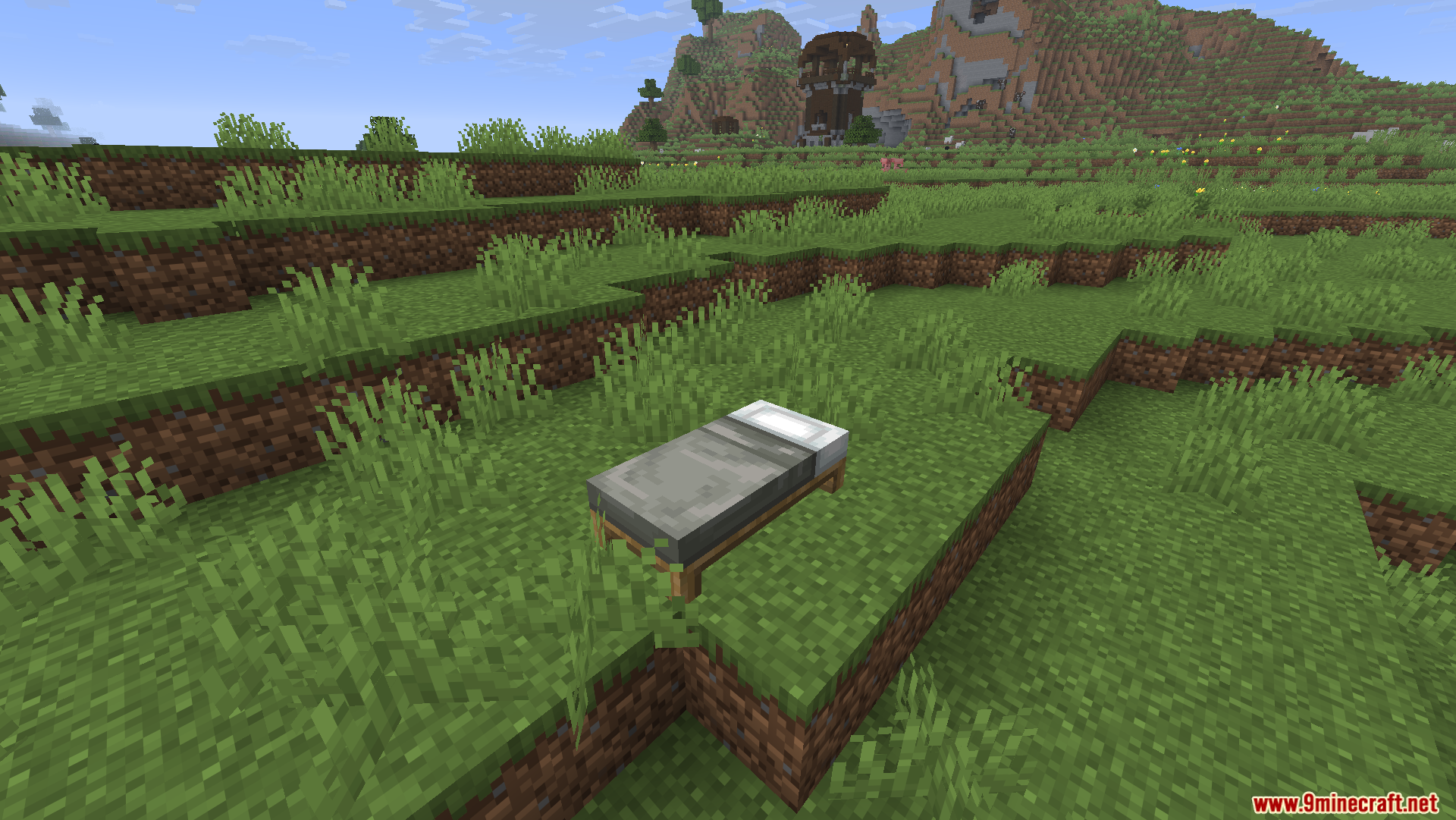 A single grey bed placed on a grassy hill
