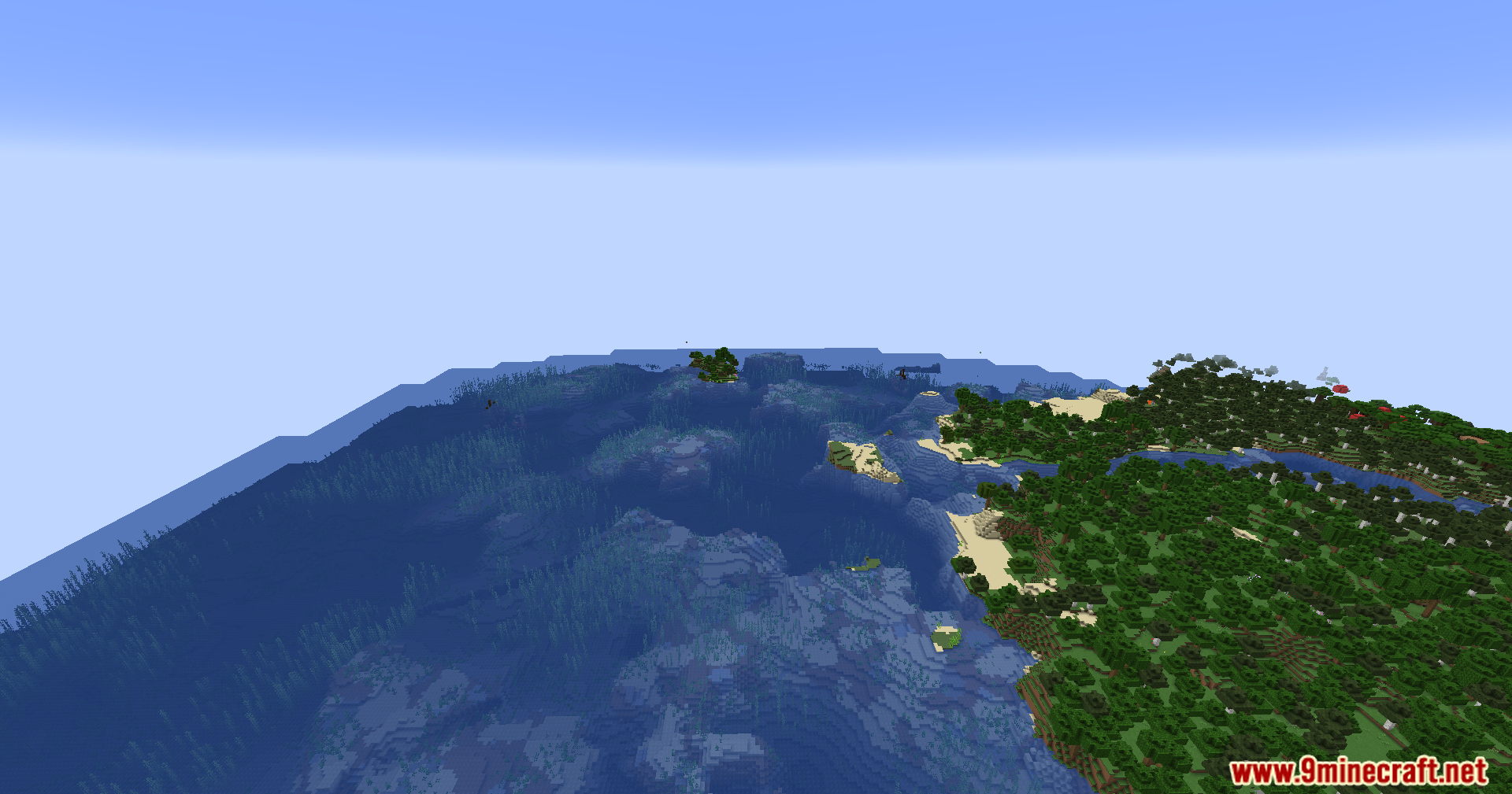 Expansive view of a forested coastline meeting the deep blue sea