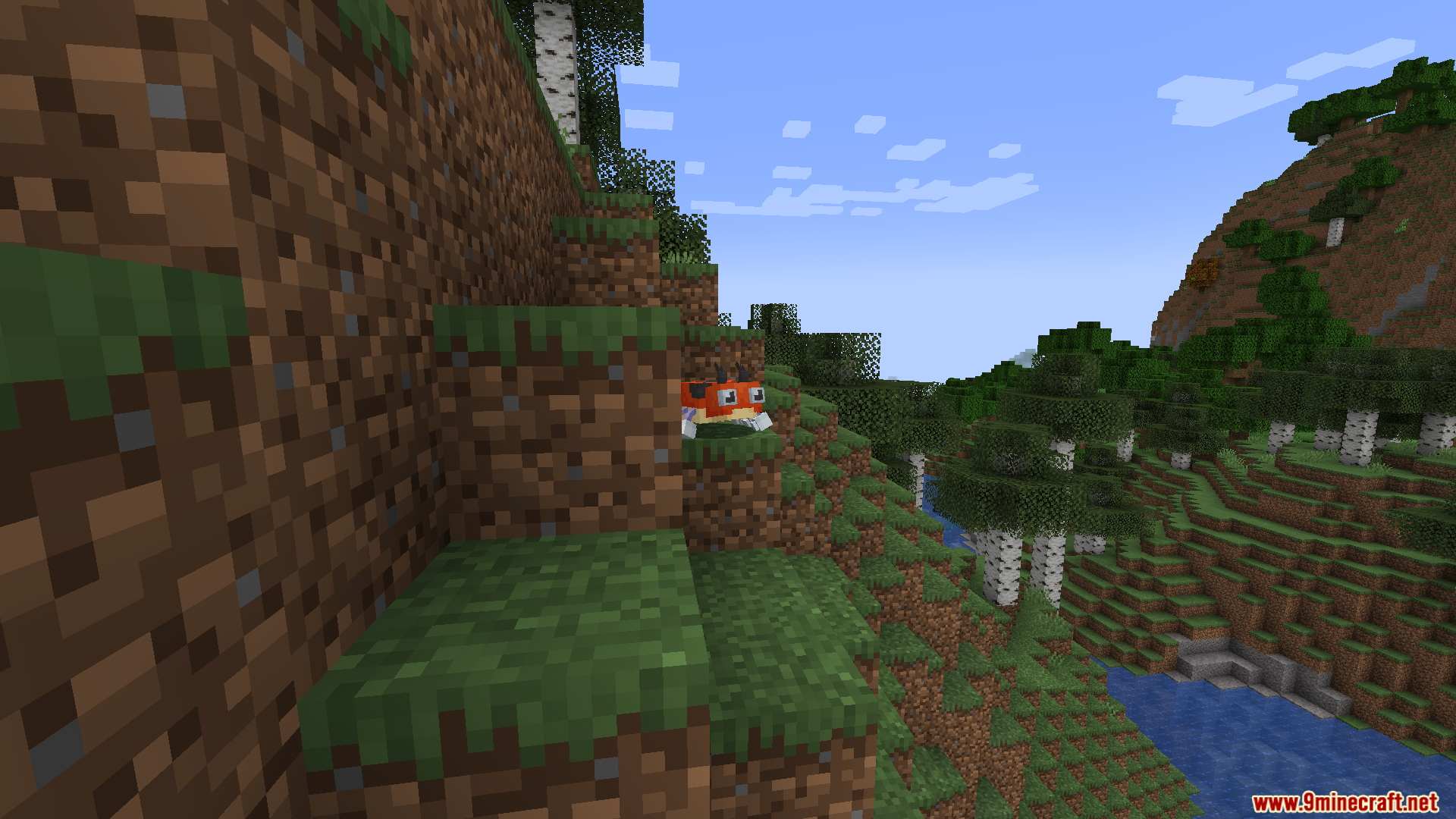 Small orange Pokemon sitting on a grassy hill in the Minecraft world